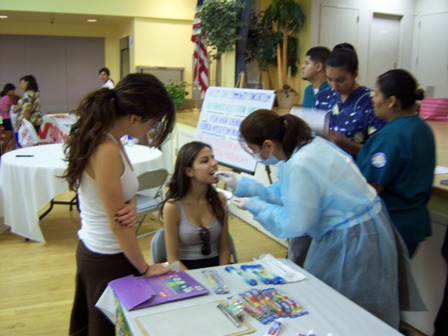 Dentist performing exam at community event